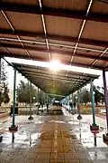 students seek shelter from rain under the solar energy plates