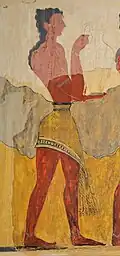 Ancient wall painting: male figure, bare chested and wearing a kilt, carries a jug to the right