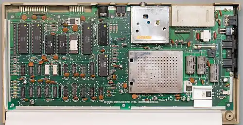 1980s Commodore 64 main board. Most of the "orange" round disc parts are decoupling capacitors.