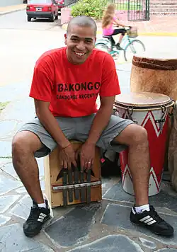Mixed Argentine with Afro ancestry playing a quisanche for candombe