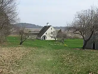 Historic wooden saltbox house with weathered shingles and a large chimney