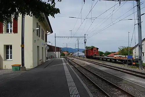 Train platform next to a two-story station building