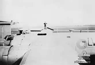 An airman standing on top of a No. 201 Flight RAAF B-24 Liberator at RAAF station Laverton