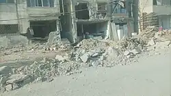 Destroyed section of a street in front of two buildings