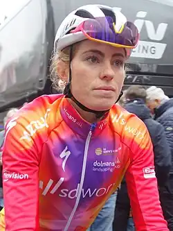 Female cyclist in red and purple jersey wearing a helmet