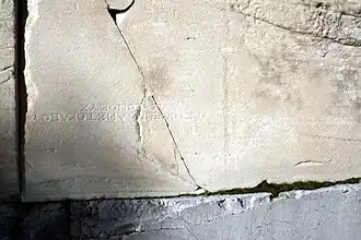 A large marble block with a small inscription in Greek capital letters.