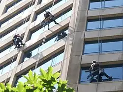 3 window washers cleaning the windows of a building