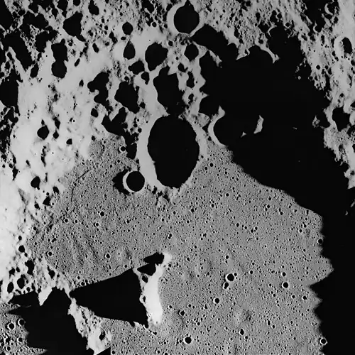 Ghost craters on the surface of the Cayley Formation in the bottom of Albategnius crater. Albategnius B crater (above center) is approximately 15&nbsp;km across. Subdued troughs trending north-northwest may be buried Imbrium sculpture. The Cayley Formation may be mantling fresh craters to produce a subdued flatbottomed bowl shape.