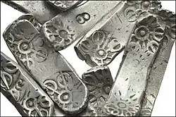 The bars found in Taxila generally use the same motifs but are elongated.[60]