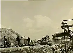 Infantrymen advance alongside tanks