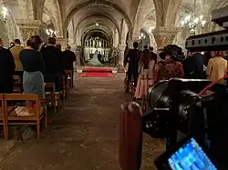 A smaller DLSR camera with a rig shooting a church wedding