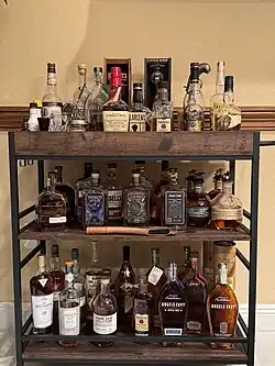 A whiskey cart with a selection of different bourbon whiskey