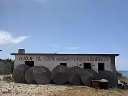 Abandoned building on Porto Palermo, contains former socialist message "Long live the albanian-chinese friendship" (RROFTE MIQESIA SHQIPTARO-KINEZE).