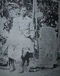 Choudhury seated next a stone fragment from the Pratapgarh Kingdom, c. 1900s.