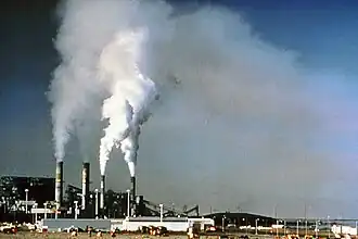 A factory with chimneys releasing smoke.