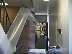 A photo of a temporary plastic air duct that leads out from an area where asbestos abatement is taking place.