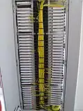 Fiber entrance cabinet with numerous trays on the sides, the cabinet connects the headend to fiber optic cables connected to optical nodes outdoors, equipment and cables outdoors are called the outside plant