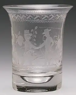 A frosted-glass beaker, uncoloured, with an engraved design.