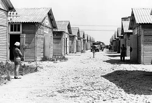 Main street of the camp with barracks and prisoners.[note 1]