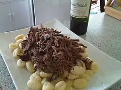 Unsauced shredded beef atop gnocchi
