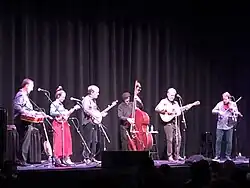 Sutton (second from right) playing guitar in 2022, in support of Béla Fleck's album My Bluegrass Heart.