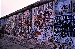 Berlin Wall graffiti reads: "In this day we stand divided--by its fall we are united", 1986