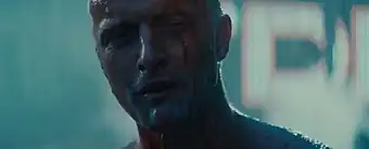 Headshot of Roy Batty, rain can be seen falling around him