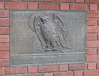 Plaque showing an owl, the moon, and text