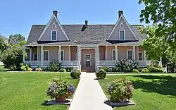 Photo shows a pink pioneer-era home.