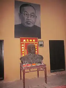 Bronze Statue of Xie Juezai at the table in the main room.