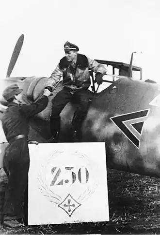A black and white photograph of a man getting down from a plane while another man shakes his hand