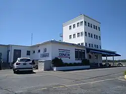 Four-story, square office building with a one-story restaurant in front