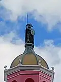 Statue of Cuauhtémoc standing above the tower dome of Casa Bonita