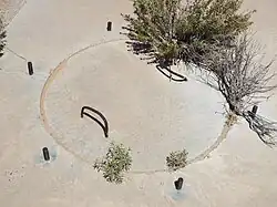 Close-up view of the second calibration target manhole cover. Around the cover protrude six equidistant pieces of rebar.