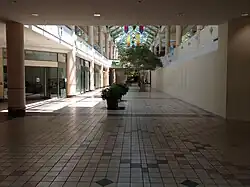 A deserted corridor of Charlestowne Mall, showing several abandoned or covered-up storefronts.