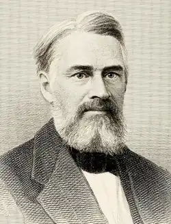 Head and shoulders woodcut print of a man in an overcoat. He has a full mustache, a beard with sideburns and has his hair combed. He wears a stern expression and is looking straight ahead.