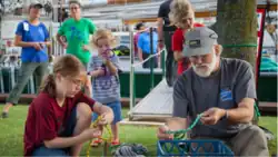 Children tying nautical knots with an adult man
