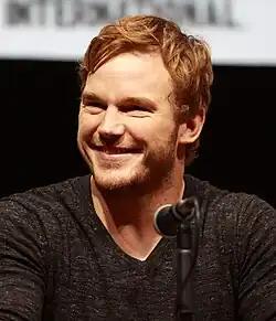 Pratt smiling behind a microphone