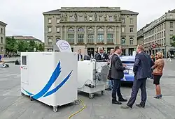 Large industrial equipment on display as people talk nearby