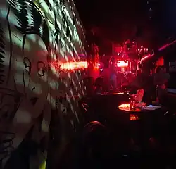 Bar seating area and wall mural under red lighting