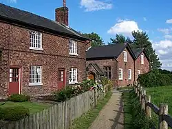row of Victorian brick cottages with gardens