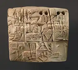 A proto-cuneiform tablet, Jemdet Nasr period, c.&nbsp;3100–2900&nbsp;BC. A dog on a leash is visible in the background of the lower panel.[32]