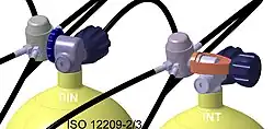 Tops of two scuba cylinders showing regulators connected via DIN and yoke connectors