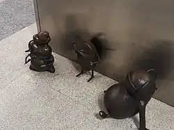 Small bronze statues of fantasy creatures at the station platform