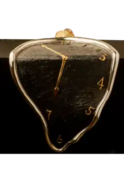 A silver melting clock with black background and golden clock hands.