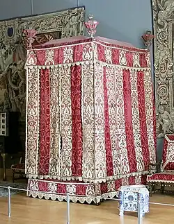 Four-poster bed from the Château d'Effiat; c.1650; natural walnut, chiselled Genoa silk velvet and embroidered silks; 295&nbsp;cm; Louvre[123]