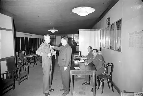 Regimental Sergeant Major Stilwell has his measurements taken for his demob suit by a tailor at the army's Demobilisation Clothing Depot at Olympia, London.