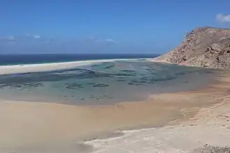 A sandy beach framed by rocky cliffs