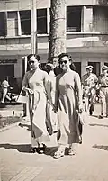 Two women wearing áo dài walking in Saigon, 1947.