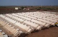 The condenser at Satapar in India consists of eleven ridges. The ridges are trapezoidal in section (top 50&nbsp;cm, base 200&nbsp;cm, two sides sloping 30-degree from horizontal, height 100&nbsp;cm) and each is 20 m long. The ridges are built over gently sloping ground. All the ridges drain into a common pipe at the lower and leading to storage below ground. Water for use is withdrawn by a hand pump. The system was commissioned in early April 2007. Total cost of the installation was Rs 117,000.